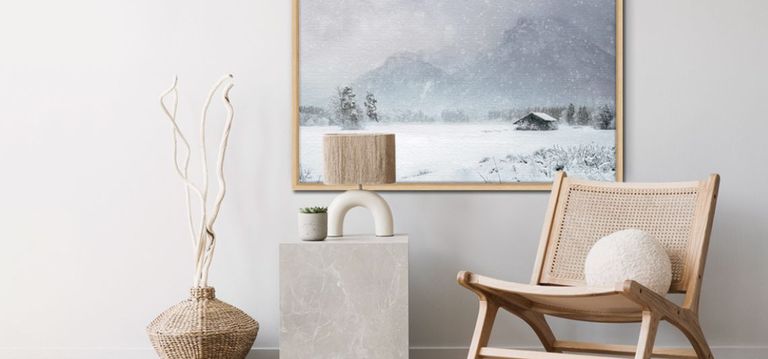 winter scene picture in wood frame behind a chair