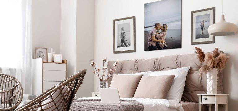 Black and White framed print of couple and canvas color print in neutral colored bedroom