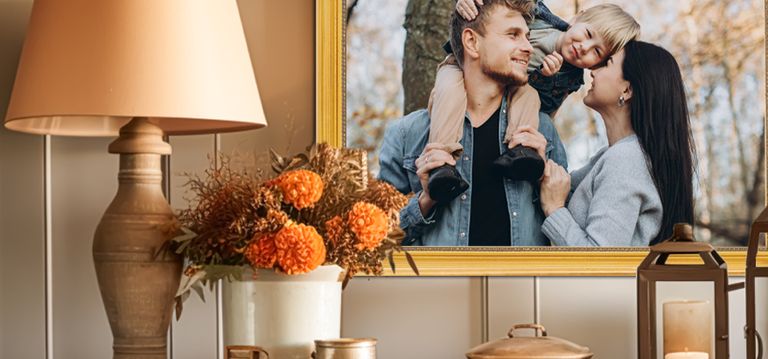 Framed photo of a family in gold frame behind a table with fall colored flowers