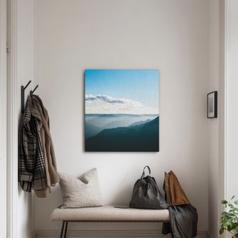 Canvas print of a landscape hanging over a bench in an entryway