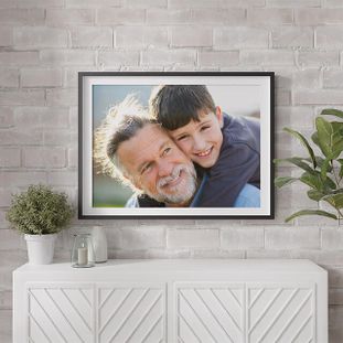 Framed picture hanging above a white sideboard