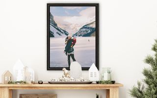 A framed photo of a mother holding her child in a snowy mountain landscape