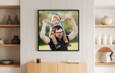 Framed photo of father and child in a bright room above a table with modern decor