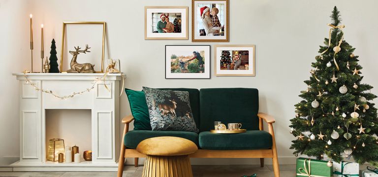 Holiday framed photos on a light colored wall near a Christmas Tree and Green furniture. 