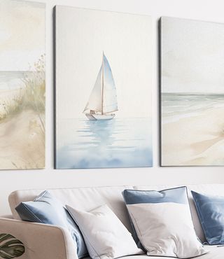 Framed canvas prints of beach and sailboat in living room