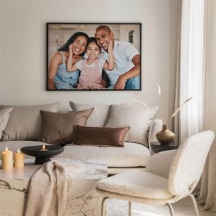 Smiling family on the couch with a framed photo on the wall