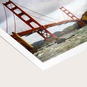Paper photo prints including Golden Gate Bridge image displayed on white surface.