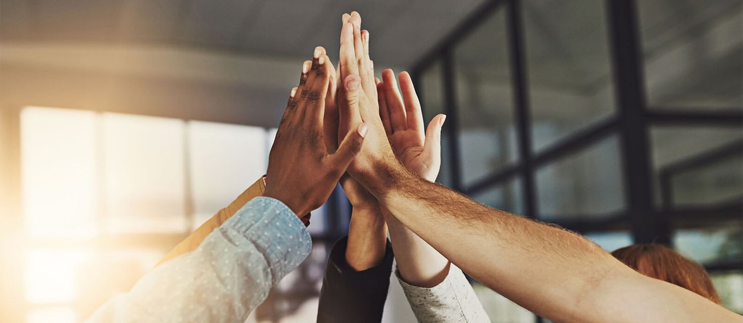Hands of several people doing a high-five