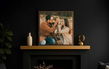 Framed canvas artwork with floating canvas frame displayed over a fireplace in dark painted room
