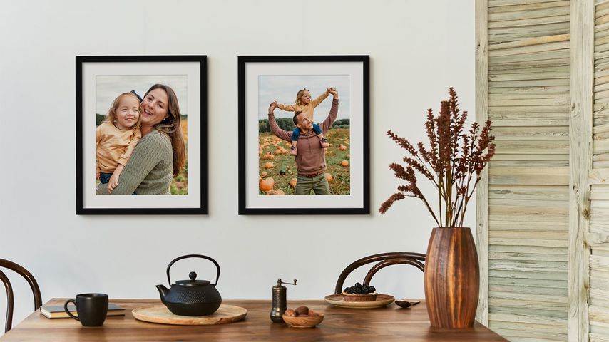 2 framed photos or parents and child with white mats in black frames with fall decor