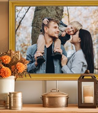 Framed photo of a family in gold frame behind a table with fall colored flowers