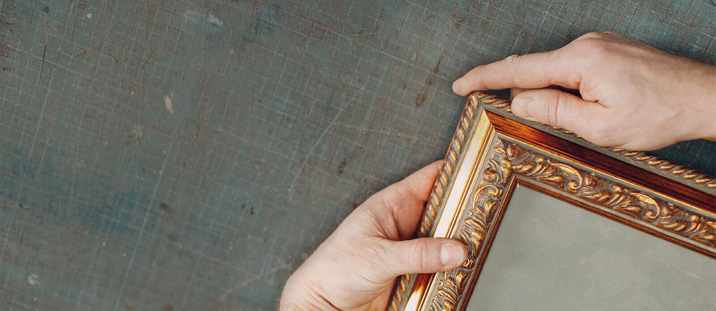 Hands holding the edge of a golden frame