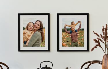 2 framed photos or parents and child with white mats in black frames with fall decor