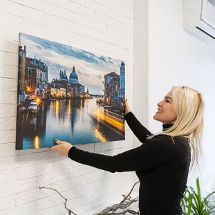 Woman hanging a framed picture on the wall