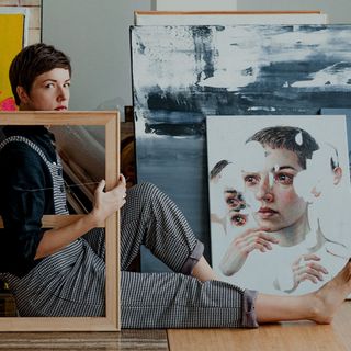 A canvas print hung behind in a foyer, behind a couch.