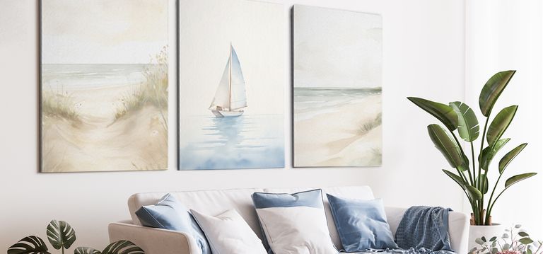 Framed canvas prints of beach and sailboat in living room