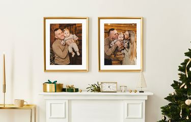 Framed prints above mantel with white mats next to decorated Christmas tree